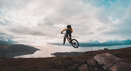 Un ciclista de montaña saltando de las rocas en Noruega.