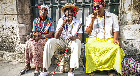 Drei Kubaner rauchen Zigarren.