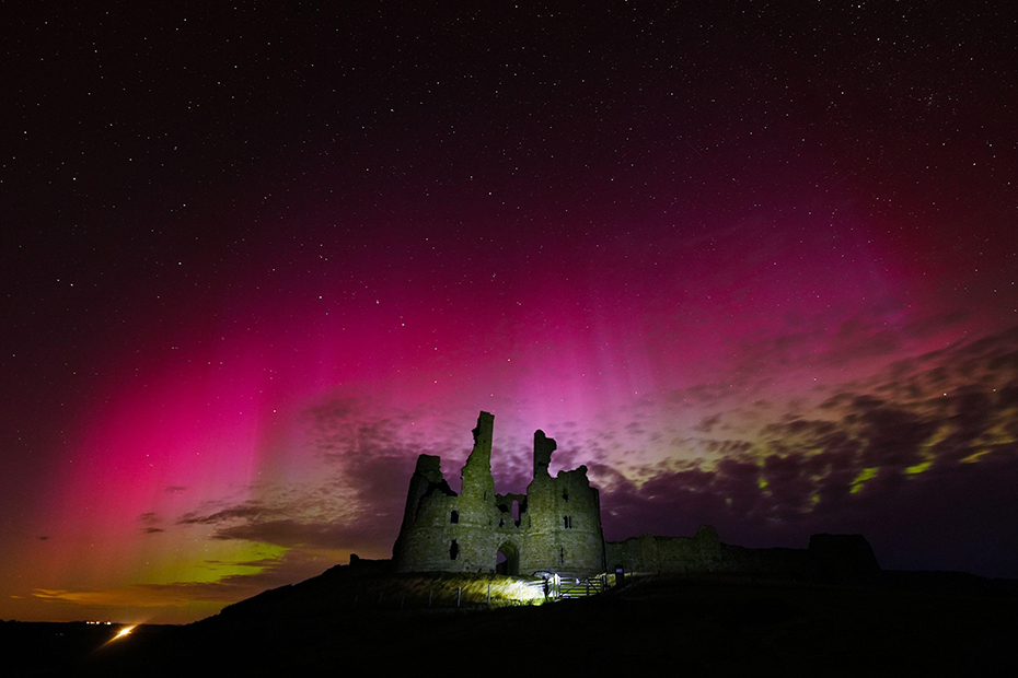 The aurora borealis, commonly known as the Northern Lights, light up the skies over the ruins of Dunstanburgh castle on the Northumberland coastline. 