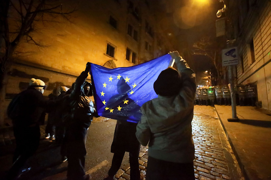 Demonstrators hold an EU flag in front of a police block rallying outside the parliament's building to continue protests against the government's decision to suspend negotiations on joining the European Union in Tbilisi, Georgia, on Monday, Dec. 2, 2024.