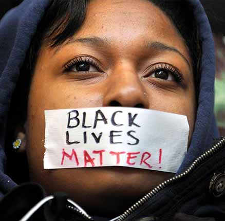 Penn State student Zaniya Joe wears a piece of tape over her mouth that says "Black Lives Matter" during a Ferguson protest organized by a group of Penn State University students on Tuesday, December 2, 2014, in University Park, PA, USA.