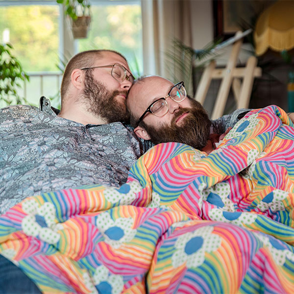 Male couple sleeping on sofa