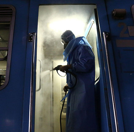 A Sri Lankan worker sprays wearing protective gear spray disinfectant Inside a train at Dematagoda railway yard in Colombo on March 17, 2020. 