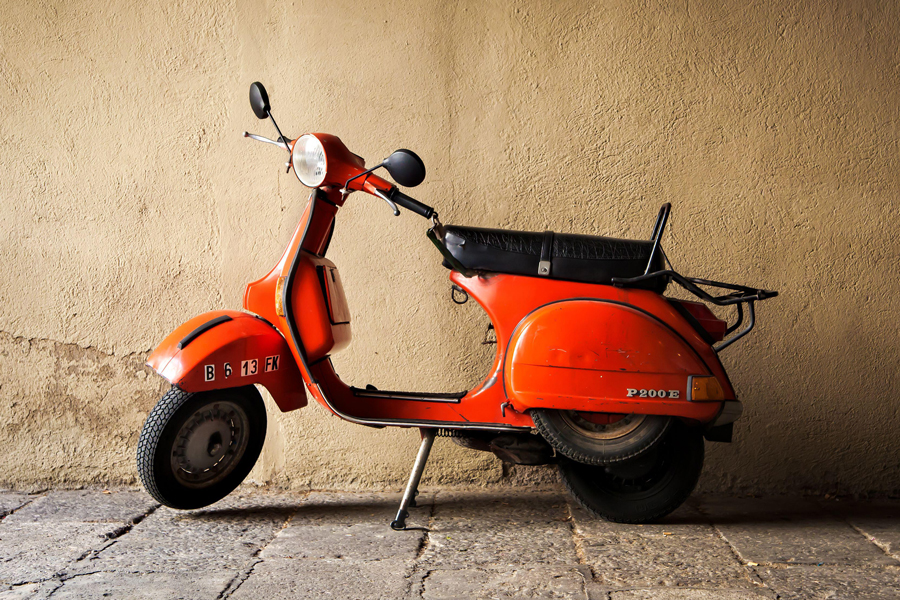 Scooter Vespa vintage rouge garé près du mur, Barcelone, Espagne, juin 2011.