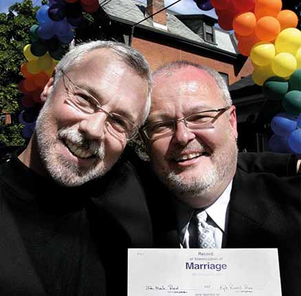 Toronto City Councillor Kyle Rae (R) and his same sex partner Mark Reid hold their marriage certificate after being legally married in Toronto, June 20, 2003.