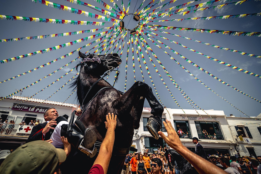 Fornells, Spain. 23rd July, 2023. A 'caixer' (horse rider) rears up on his horse surrounded by a cheering crowd during the traditional 'Jaleo' at the Sant Anton Festival in Fornells
