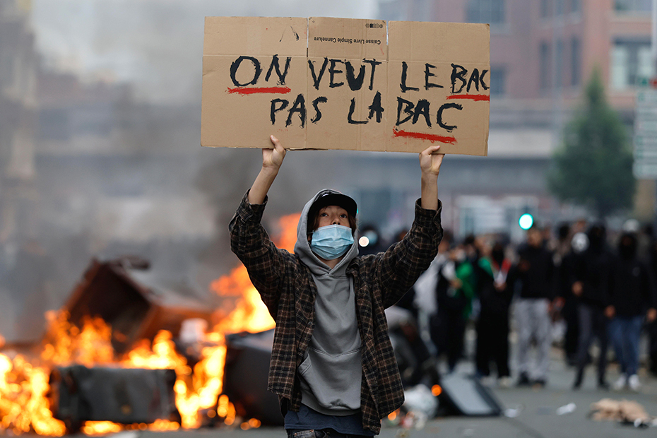 A student holds a board reading, "we want the BAC (High School Diploma) Not the BAC (Anti-criminality units)" during a protest to demand more resources at school, in Lille, France