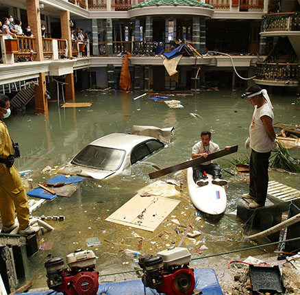 Emergency crew search for bodies in the flooded lobby of the Seapearl Resort at Patong Beach on Phuket Island in Thailand.
