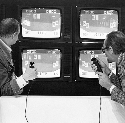 Two visitors of the International Radio Show in Berlin, which will officially be opened on the 26th of August in 1977, test a video game which can be played on TV screens on the 25th of August in 1977