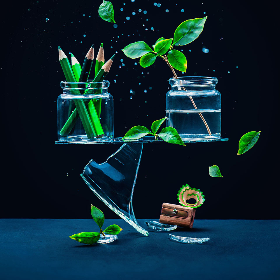 2AM1HN2 – Glasgefäße mit Bleistiften und Pflanzen, die auf einer Scherbe balancieren, Konzept Kunst vs. Natur