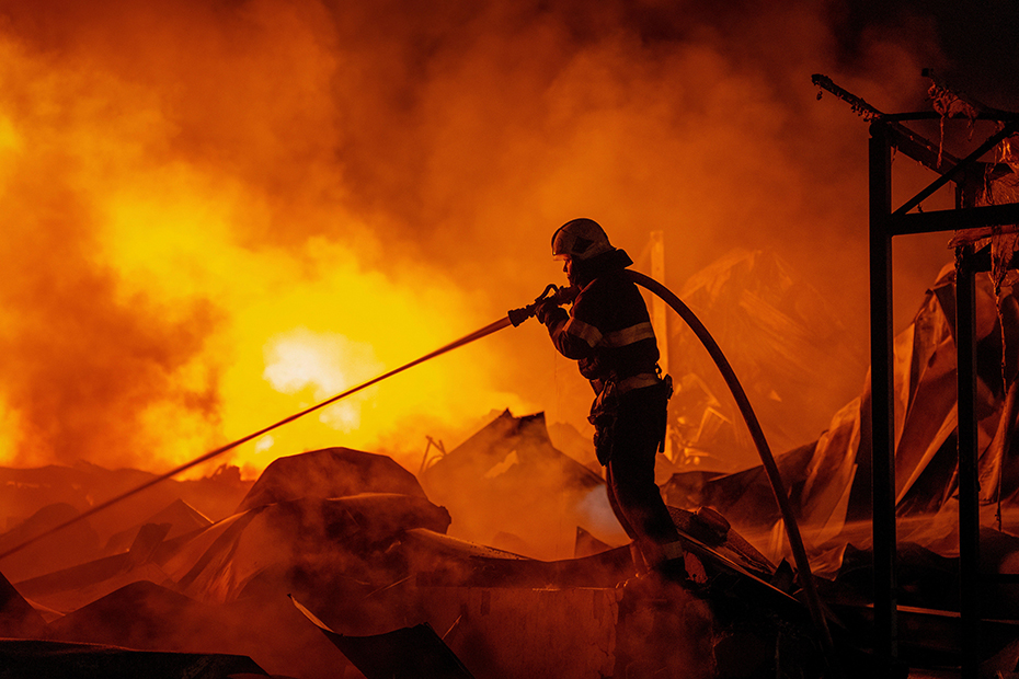 Firefighters put out a fire after Russian missiles hit a warehouse in Kyiv, Ukraine