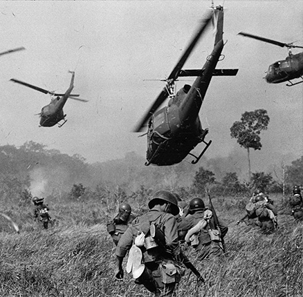 Des hélicoptères de l'armée américaine survolent la zone en déversant des rafales de mitrailleuse dans la lisière des arbres pour couvrir l'avancée des troupes terrestres sud-vietnamiennes lors d'une attaque contre un camp du Viet Cong.