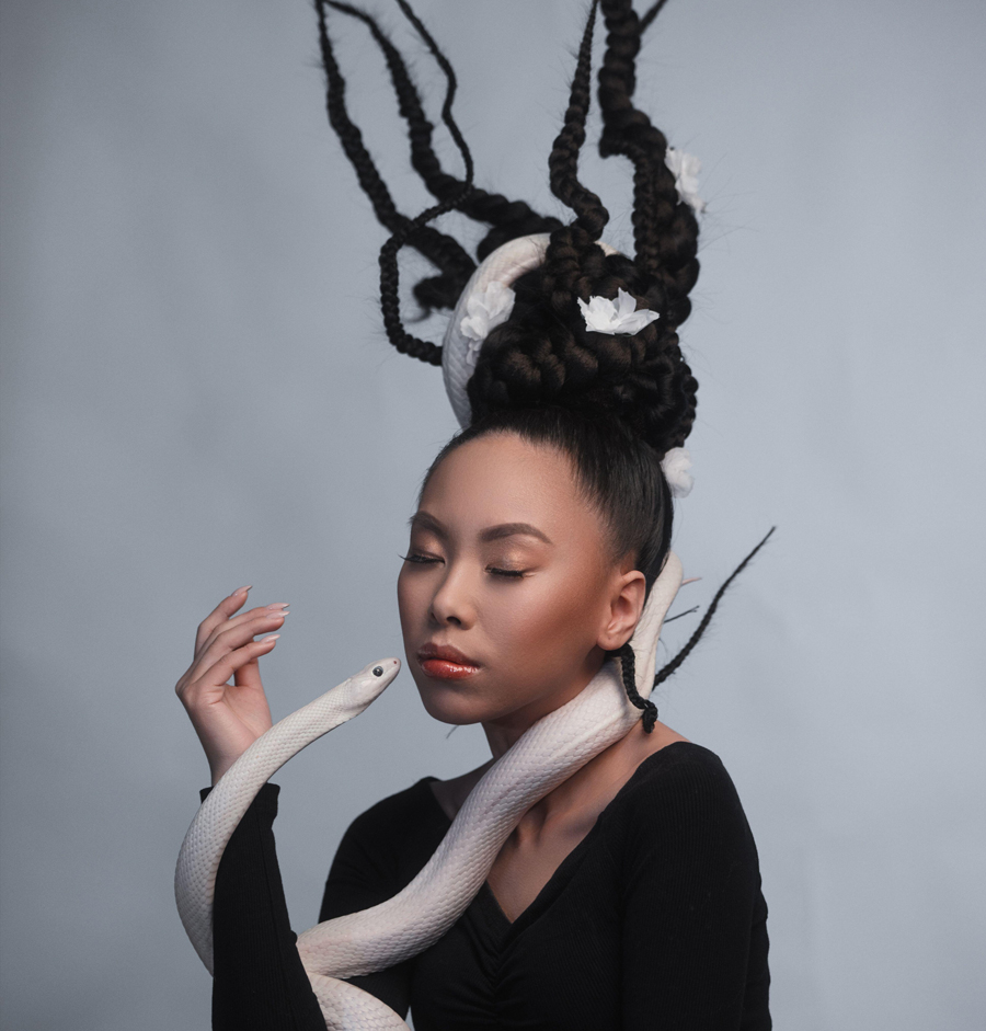 Studio portrait of young asian woman with white snake