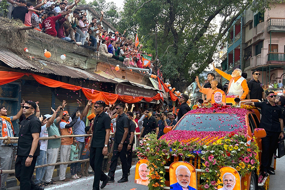 Der indische Premierminister Narendra Modi grüßt Unterstützer aus einem Fahrzeug während einer Straßenparade in Varanasi, Indien.