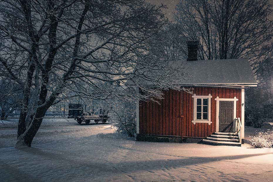 Public cozy old cafe place with snow mood at winter evening in Finland. Light snowflakes.