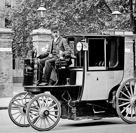 An electric cab with driver and two passengers in Berlin in 1900.