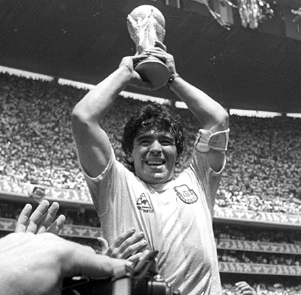 Argentine star Diego Maradona holds up the World Cup trophy as he is carried off the field after Argentina defeated West Germany 3-2 to win the World Cup soccer championship in Mexico City June 29, 1986. REUTERS/Gary Hershorn AS