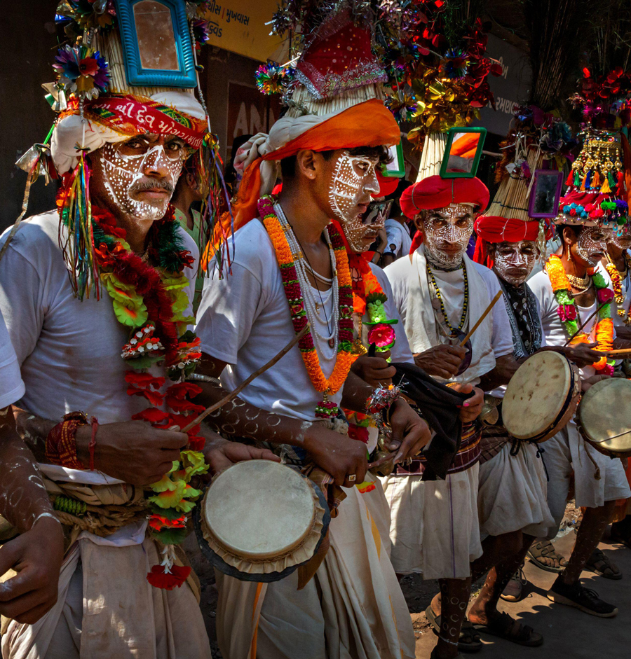 Uomini tribali Rathva con il viso dipinto durante la festa tribale annuale di Kawant nel Gujarat, India