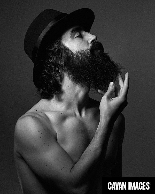 Portrait of a man with beard and hat. Shirtless. black and white.