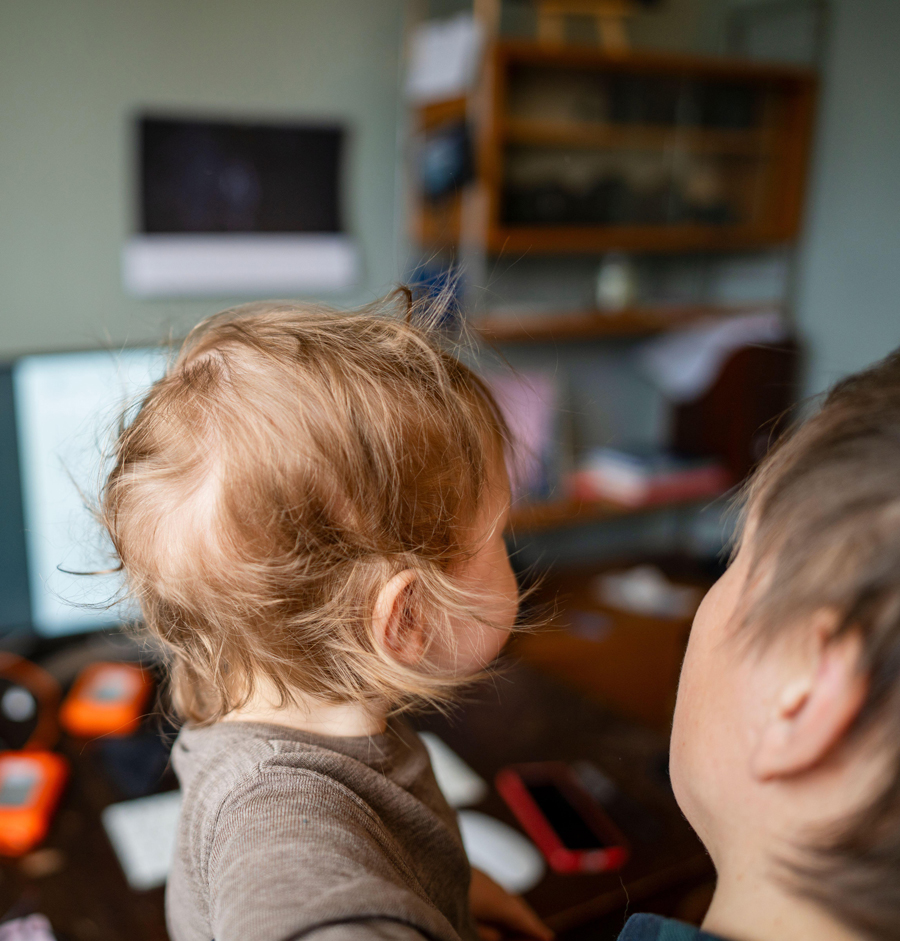 High angle view of baby boy in arms of person at child care
