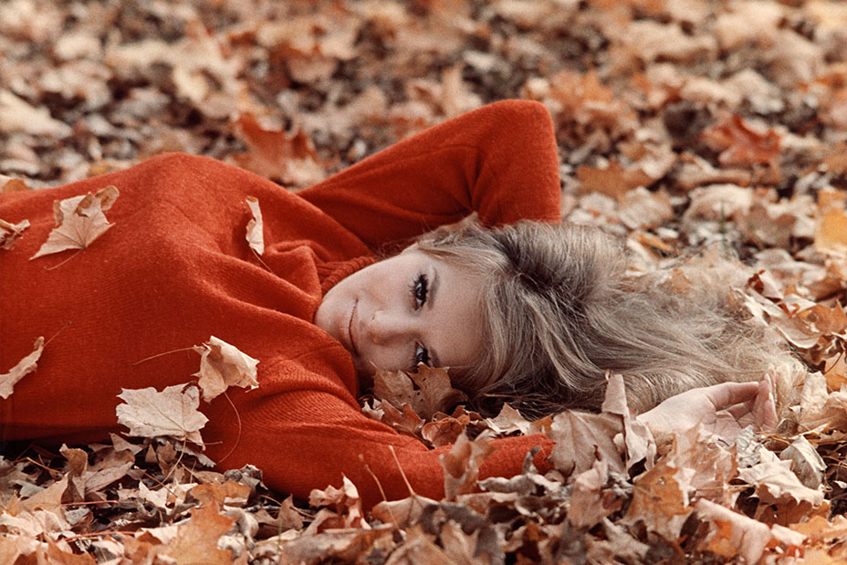 1970s portrait of model in autumn leaves. 
