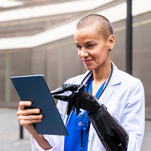 Smiling female doctor using tablet PC with artificial hand