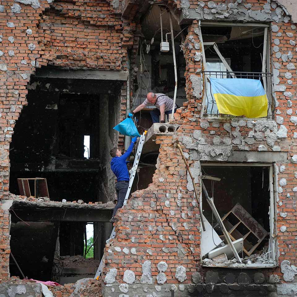 Residents take out their belongings from their house ruined by the Russian shelling in Irpin close to Kyiv, Ukraine, Saturday, May 21, 2022.