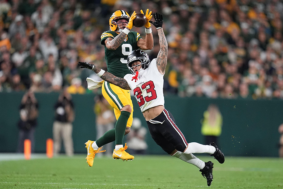 Green Bay Packers' Christian Watson catches a pass in front of Atlanta Falcons' Jessie Bates III during the second half of an NFL football game in Green Bay