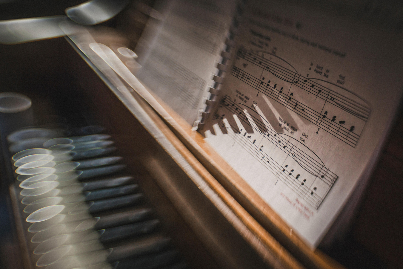 Morning sun sparkles on piano keys with sheet music creative blur