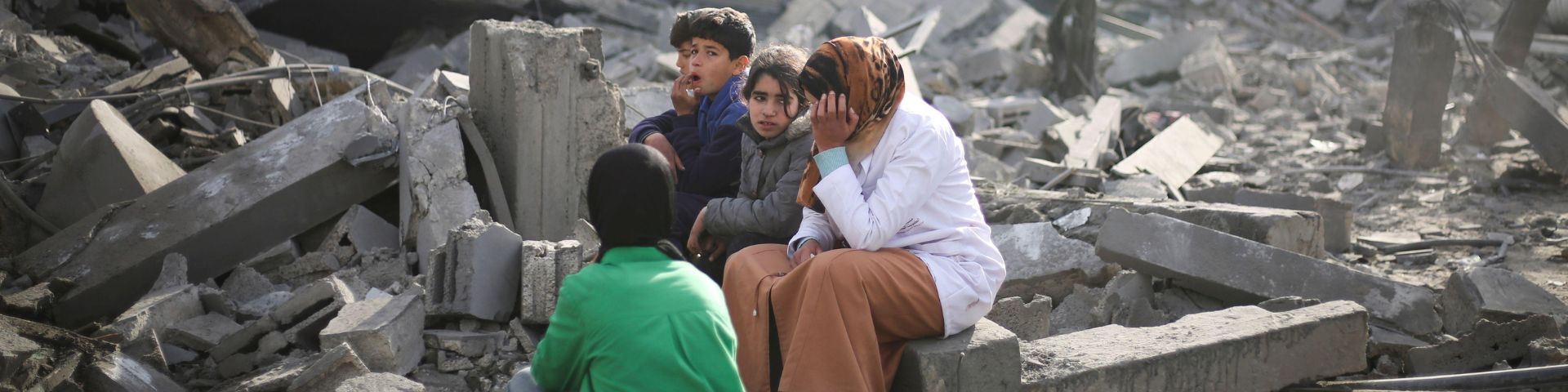 Palestinians sit by the destruction from the Israeli bombardment of the Gaza Strip in Rafah on Monday, Feb. 12, 2024. 