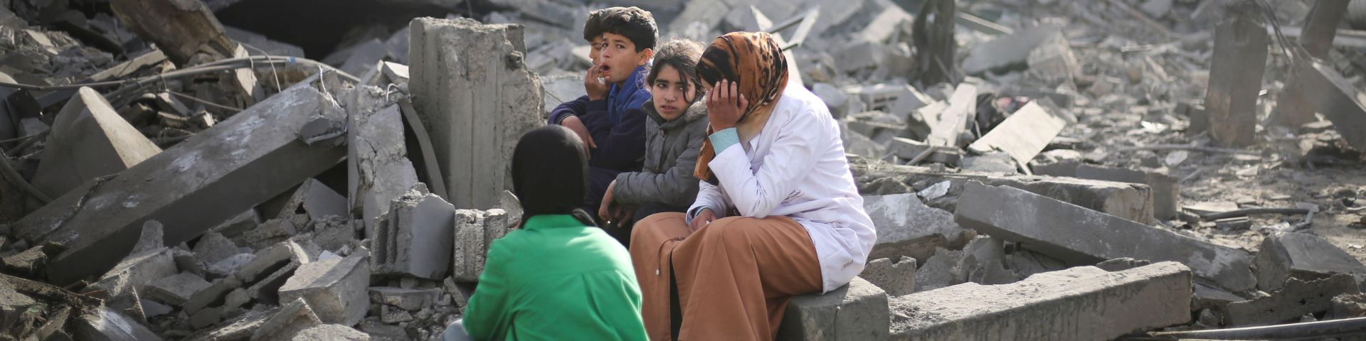  Des Palestiniens s'assoient à côté des décombres causés par les bombardements israéliens sur la bande de Gaza à Rafah le lundi 12 février 2024.