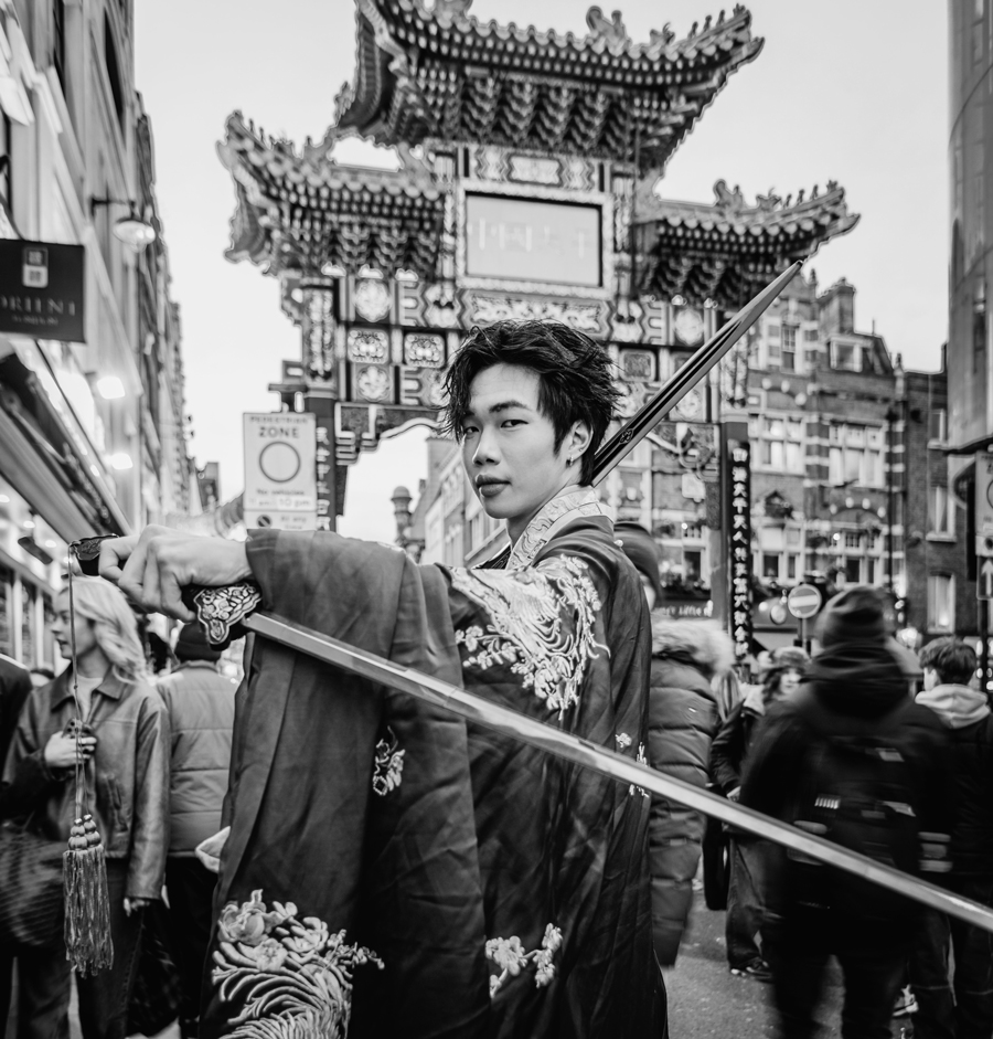 Un uomo cinese indossa un tradizionale hanfu con due dao (spade) e si prepara ad accogliere il capodanno lunare del serpente nella Chinatown di Londra.