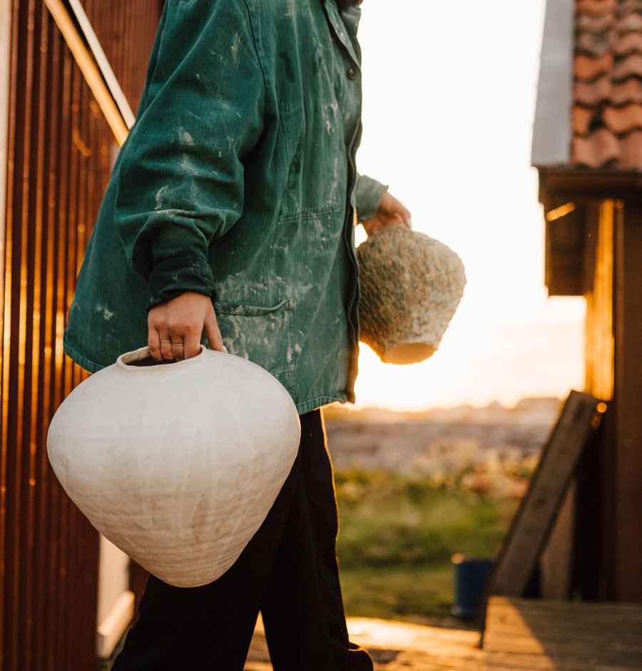 oung woman carrying handmade vases