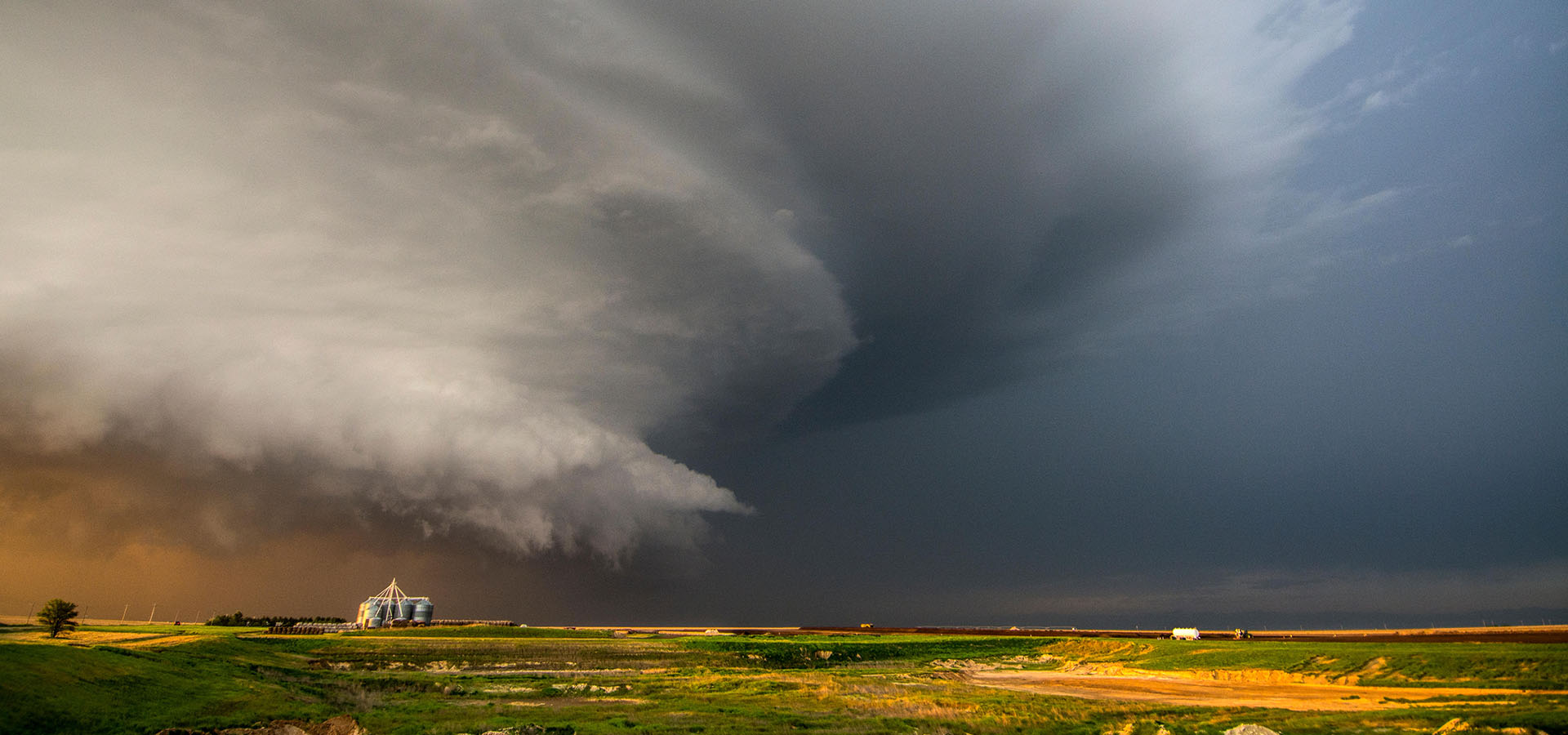 Ein tornadoerzeugender Superzellen-Gewittersturm, der bei Sonnenuntergang über Ranchland in der Nähe von Leoti, Kansas, wirbelt.