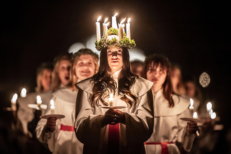 Alida Freding wears a crown of candles symbolising St Lucy as she leads the celebration of Sankta Lucia: Festival of Light at York Minster, UK.