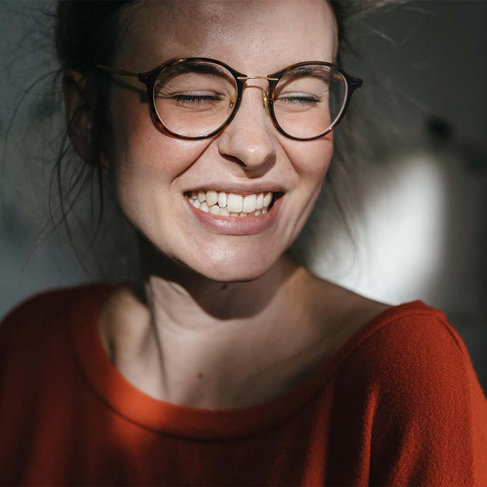 Ritratto di giovane donna felice con occhiali.