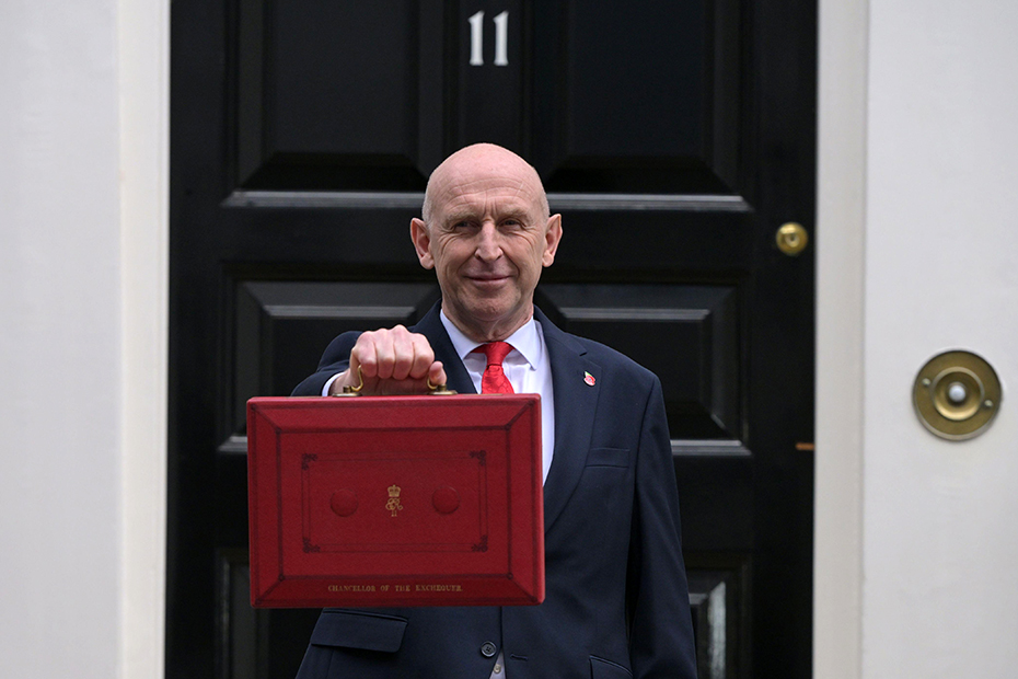 Chancellor of the Exchequer John Healey poses on the doorstep of 11 Downing Street with the ministerial red box before heading to the House of Commons to deliver the budget statement in London