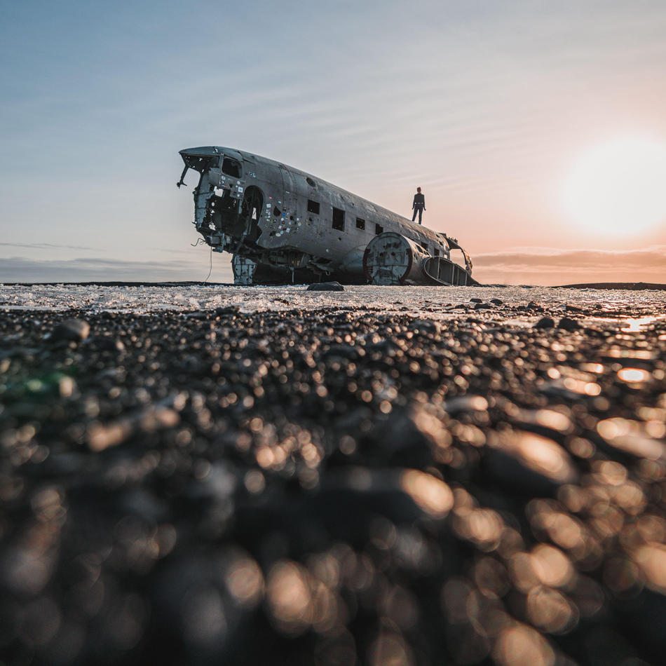 silhouette of a person standing on solheimasandur plane wreck in Iceland against the sky at sunset