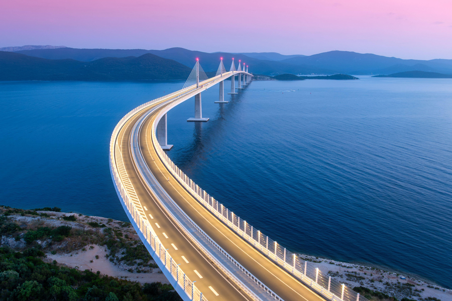 Vue aérienne du pont moderne de Peljesac et de la mer bleue la nuit.