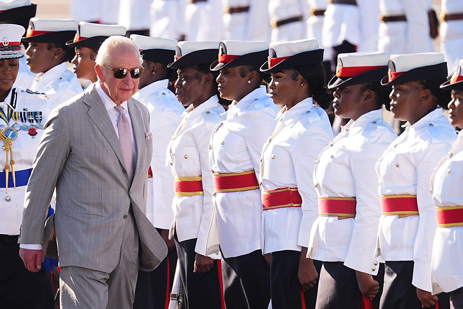 King Charles III inspects the guard of honour, made up of members of the Royal Bahamas Police Force and the Royal Bahamas Defence Force, as he arrives at Lynden Pindling International Airport, in Nassau