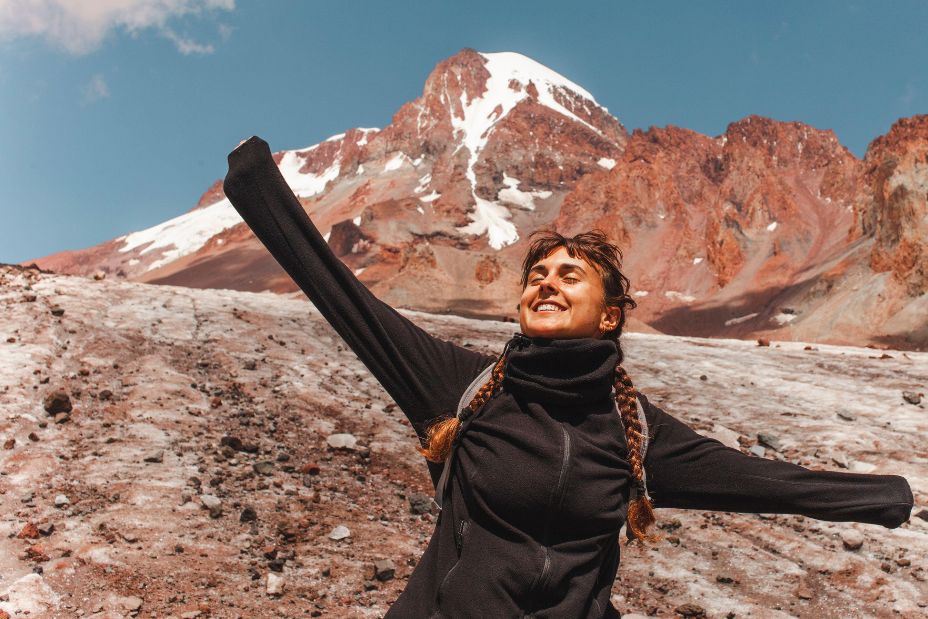 Carefree woman in front of mount Kazbek on sunny day - Image ID: 2WE6F8C (RF)