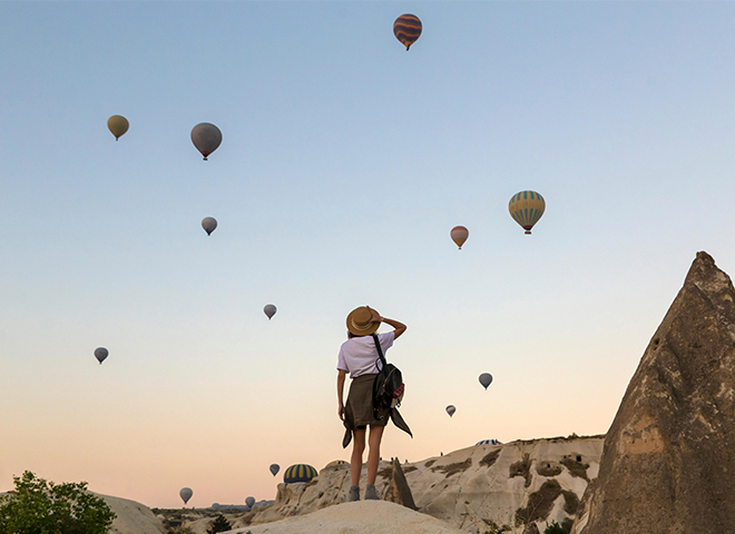 Junge Frau und Heißluftballons, Göreme, Kappadokien, Türkei