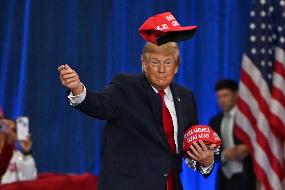 President Donald Trump throws a hat into the crowd as he arrives at a campaign rally at Lubbock Memorial Civic Center,