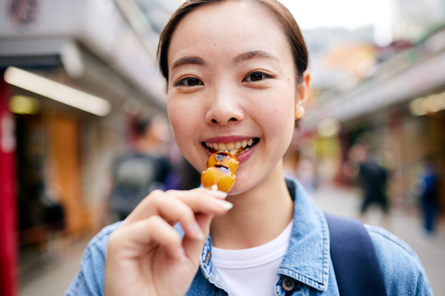 Asian woman eating street food at the temple