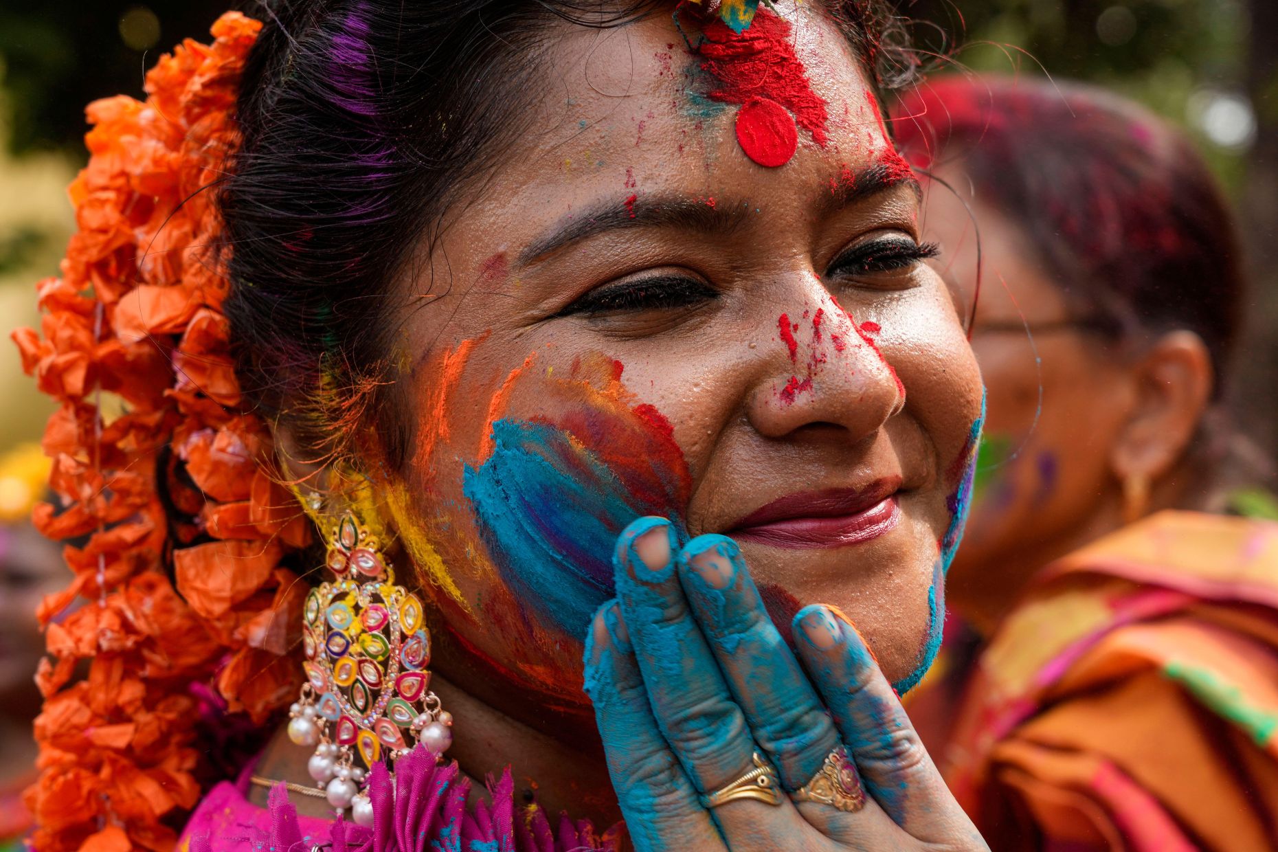 Eine Frau trägt farbiges Pulver auf eine andere auf, während sie Holi, das Festival der Farben, in Kolkata, Indien, am Montag, den 25. März 2024, feiern. Das Festival läutet den Frühling ein. (AP Foto/Bikas Das) - Bild-ID: 2WWM3GR (RM)