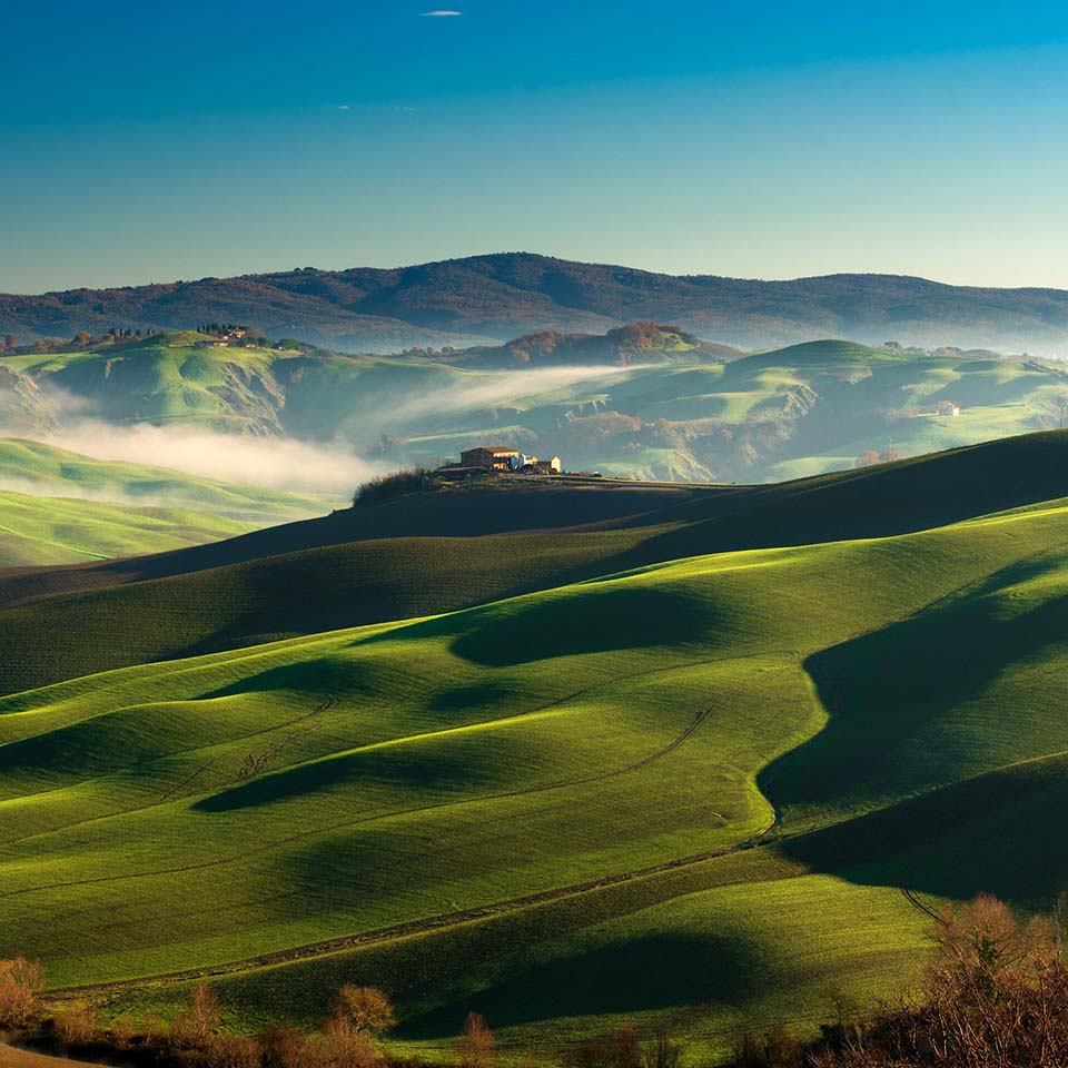 2E8WK7K – Grüne weiche Hügel an einem sonnigen Wintermorgen in der Landschaft der Crete Senesi in der Nähe von Asciano, Siena