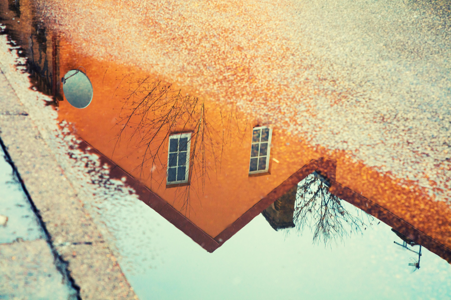 Reflet d'une maison dans une flaque d'eau
