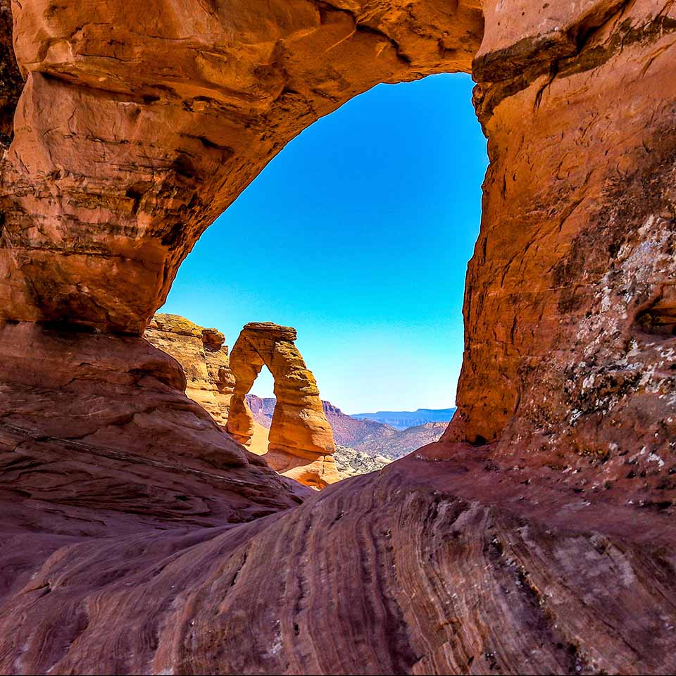 MR0FX7 – Arches-Nationalpark, Moab, Utah. Der Blick von einem der kleineren Bögen zeigt den Delicate Arch im Hintergrund. Ähnelt einem Katzenauge