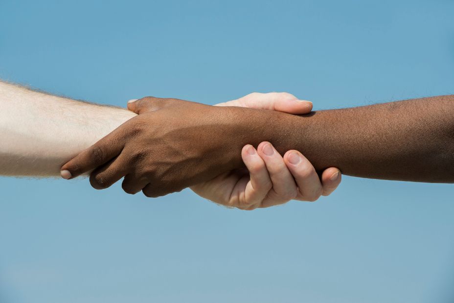 Indian and English hands. Western and Eastern hand shake against a blue sky. india. 