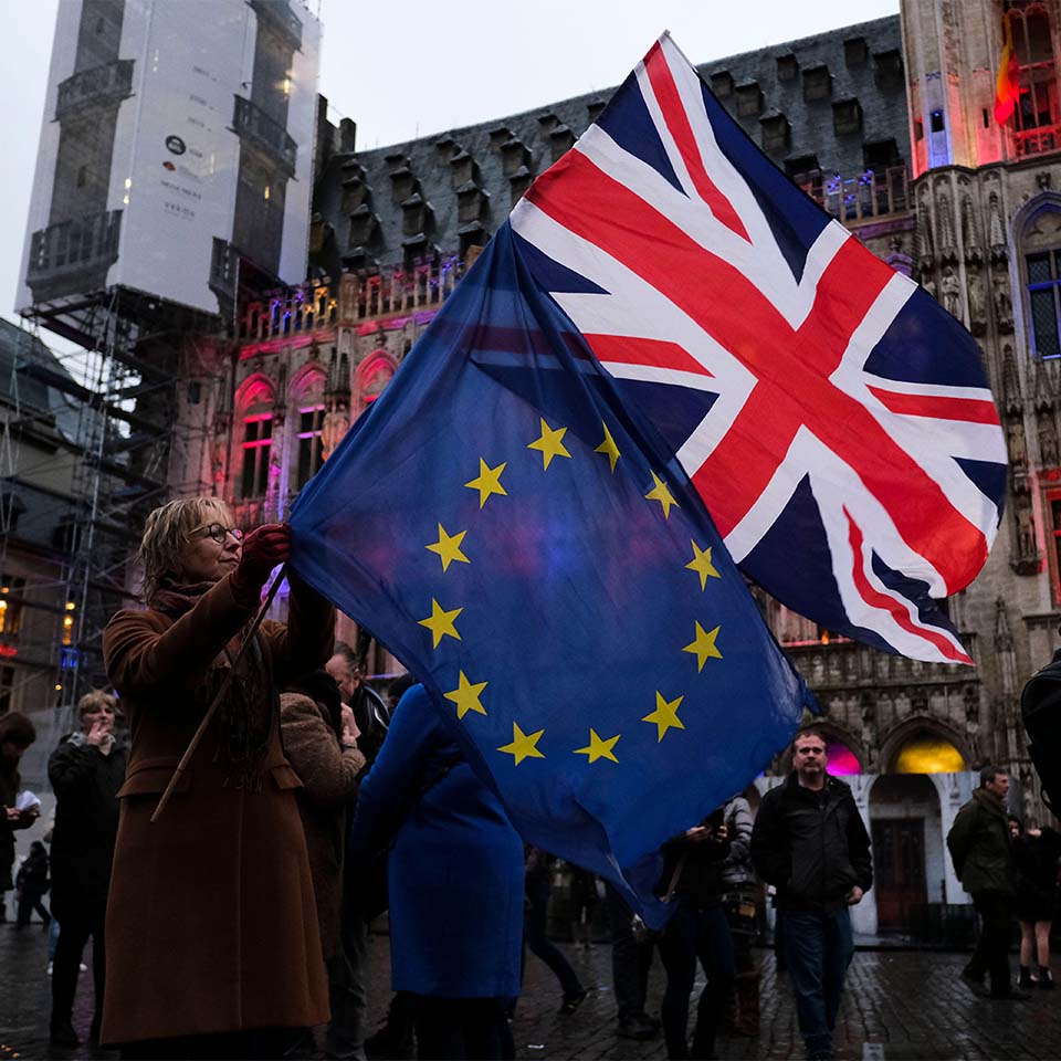 2AT59BD - Brussels, Belgium. 30th Jan, 2020. A woman holds a European flag and a Union Jack flag on the Grand Place during an event to underline its long friendship with the British. 